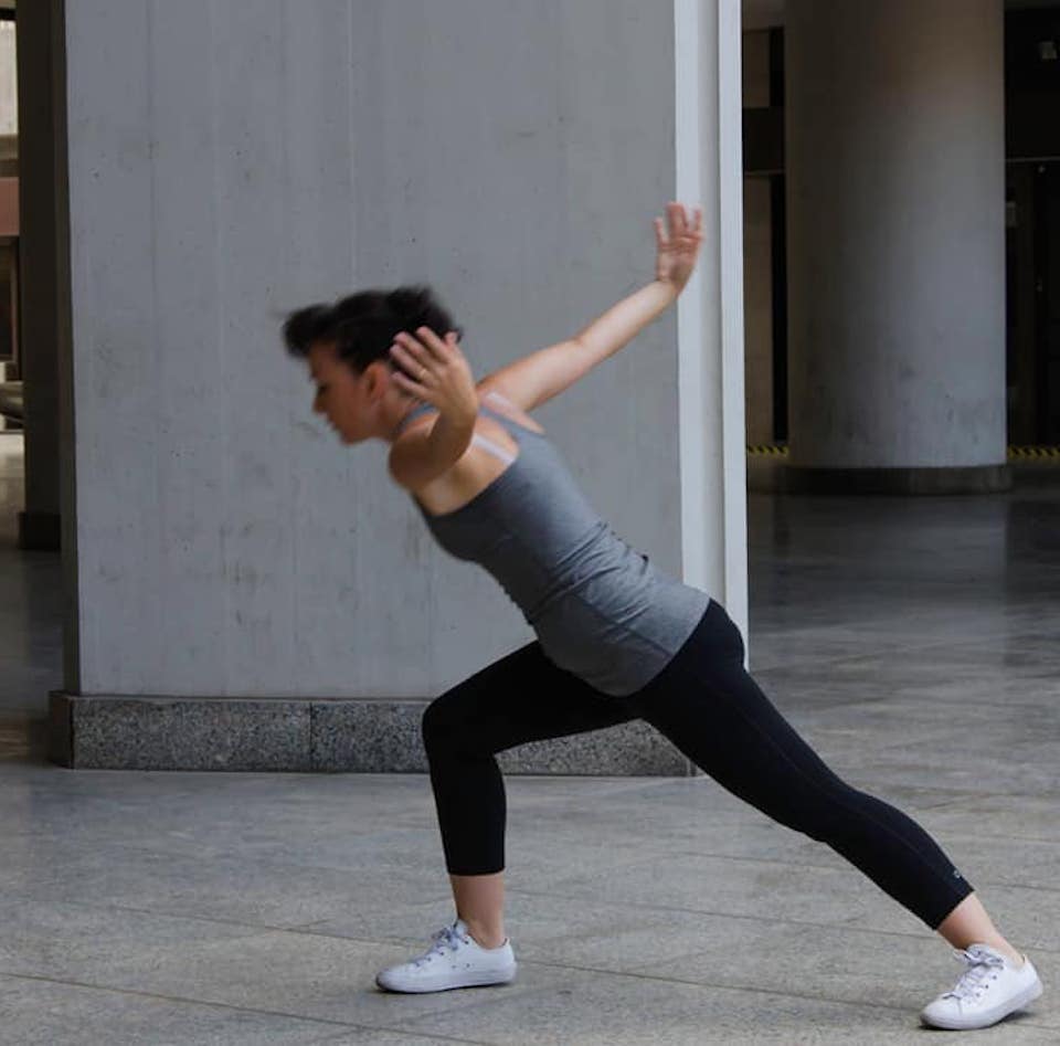 Simona moving through a wide contemporary dance position